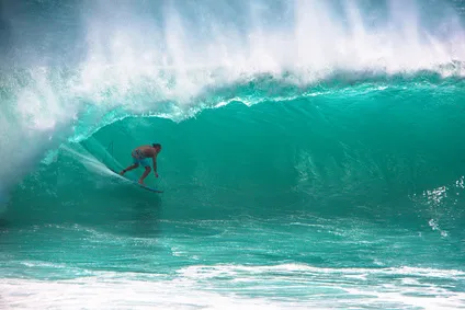 Ein Surfer reitet eine riesige Welle beim Big Wave Surfing