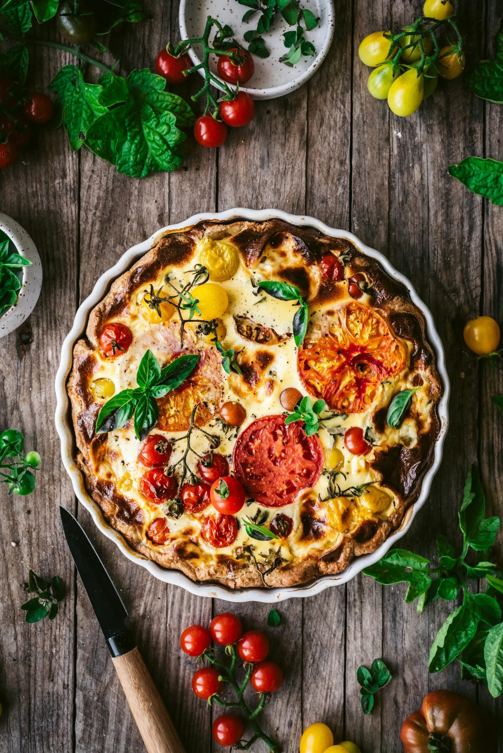 Eine gebackene Tomaten Quiche mit Mascarpone garniert mit Basilikum