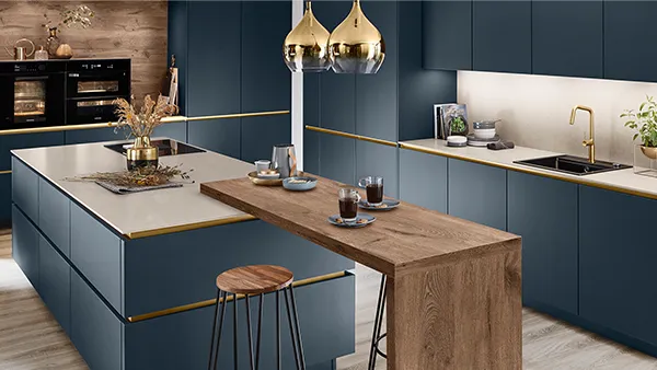 Eine moderne Küche in Fjordblau mit goldenen Akzenten und Holztresen