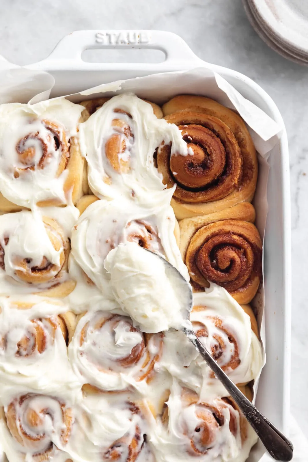 Eine Reihe perfekt gebackener Zimtschnecken, glänzend und appetitlich, in einer Backform