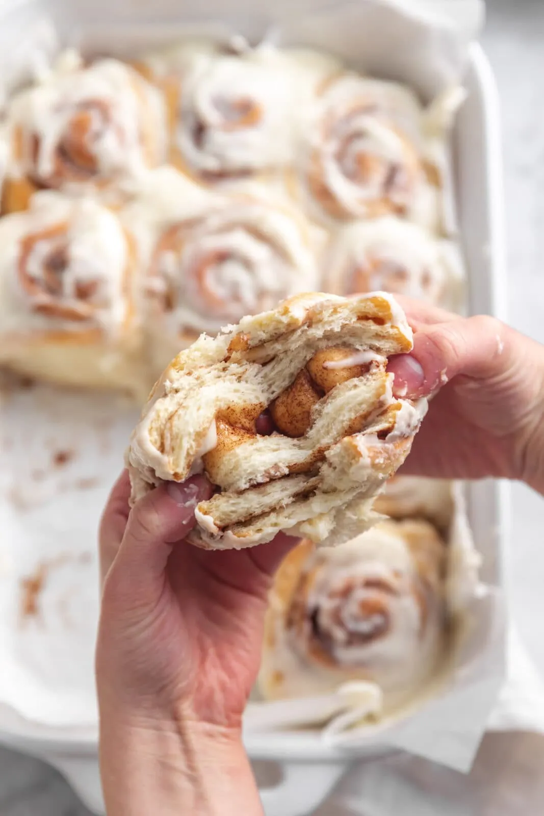 Eine selbstgemachte Zimtschnecke, aufgeschnitten, um die klebrig-saftige Mitte und die Zimtfüllung zu zeigen