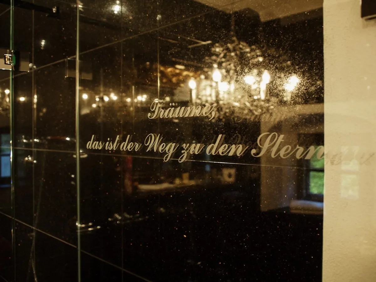 Elegantes Badezimmer in Schwarz und Gold mit großem Barockspiegel