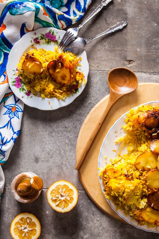 Knuspriges Tahdig mit goldbraunen Kartoffelscheiben als Boden des Reises