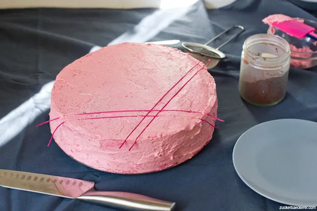 Nahaufnahme des Schoko-Himbeer-Tortenstücks, das die dicken, dunklen Kuchenschichten und die hellrosa Creme zeigt