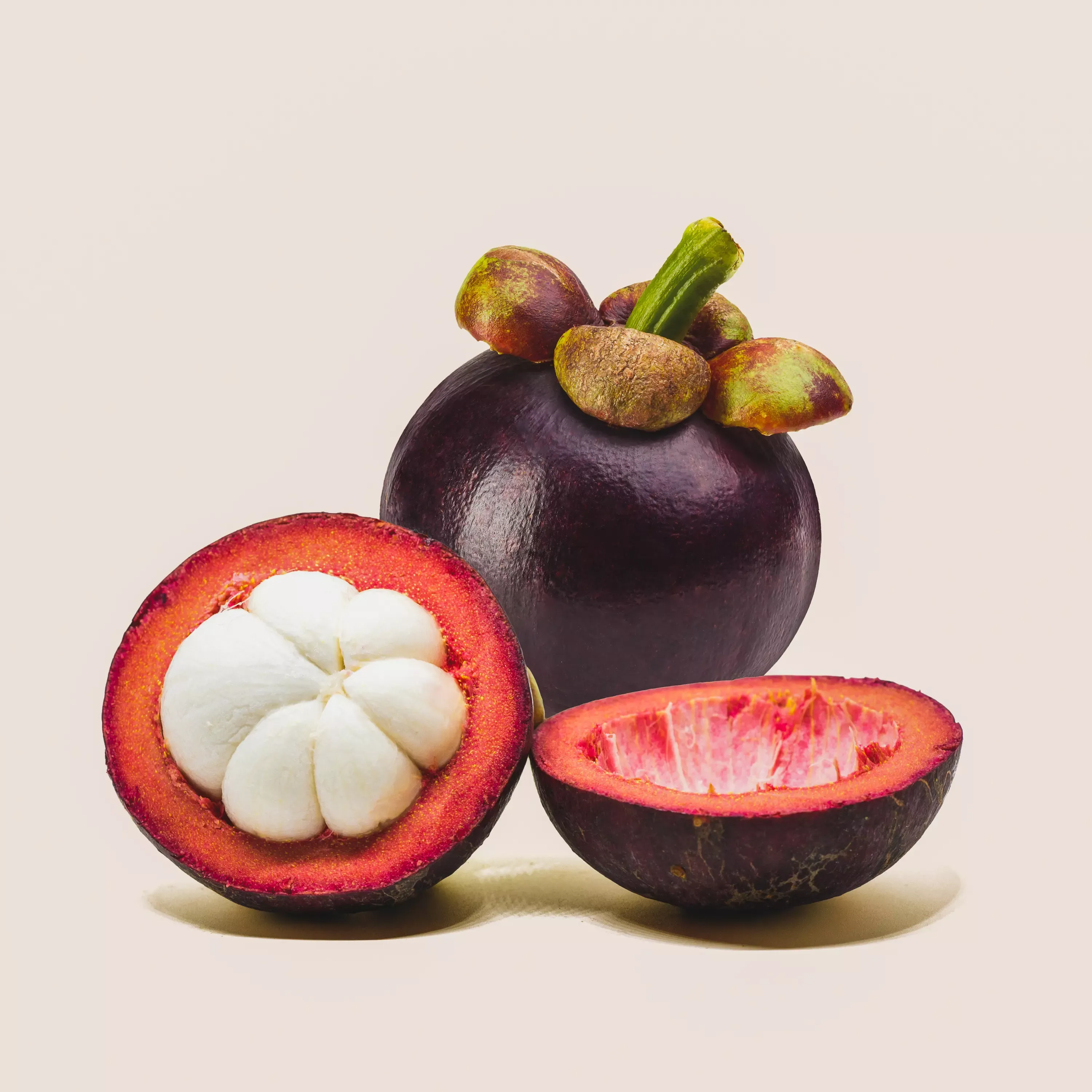Nahaufnahme einer aufgeschnittenen Mangosteen, die das weiße, saftige Fruchtfleisch und die violette Schale zeigt