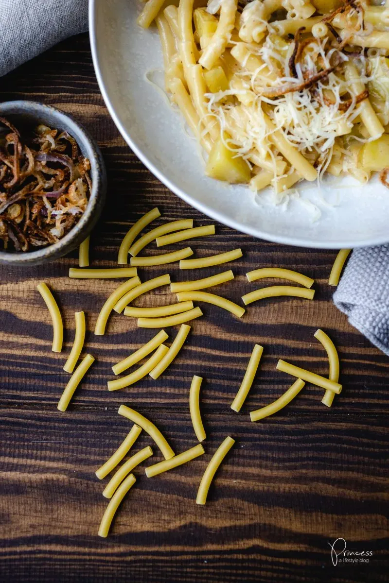 Nahaufnahme von Älplermagronen in einer gusseisernen Pfanne, frisch zubereitet