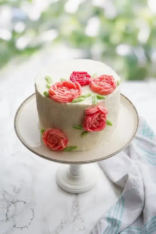 Nahaufnahme von kunstvollen Buttercreme-Rosen auf einer Torte
