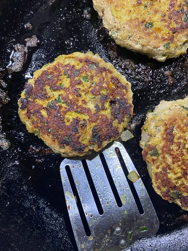 Putenburger braten in einer Pfanne mit Olivenöl
