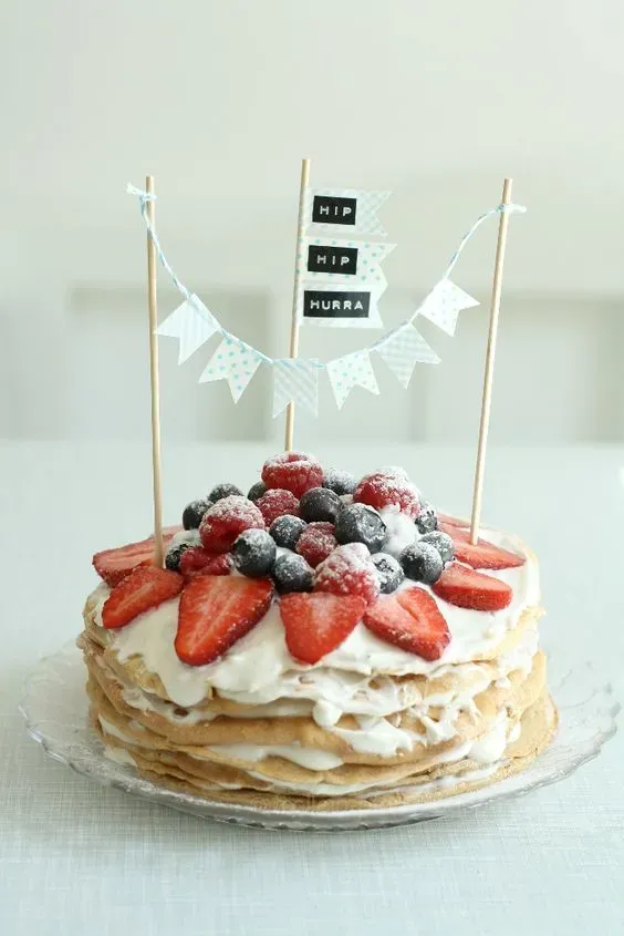 Schicht-Pfannkuchentorte mit Beeren und Puderzucker