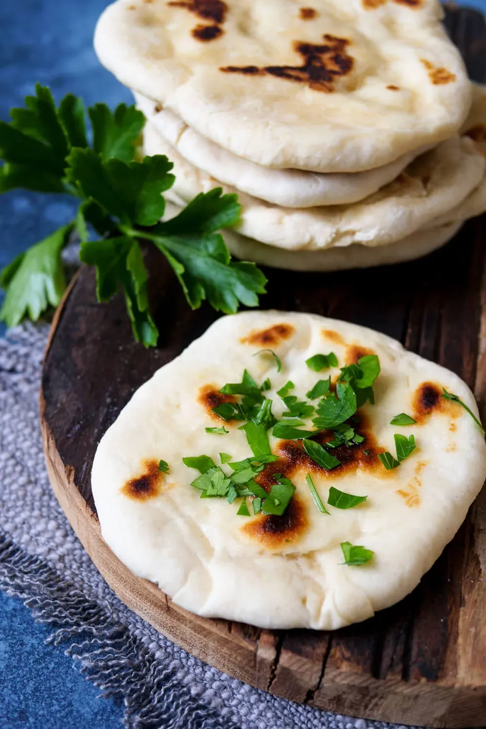 Selbstgebackenes Naan-Brot, bestreut mit Kräutern und Butter