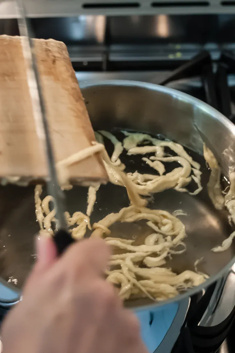 Spätzle fallen ins kochende Wasser