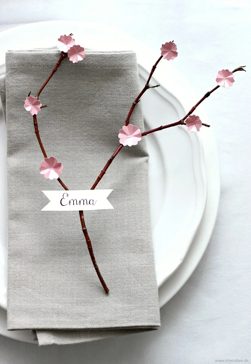 Tischdekoration mit Kirschblütenzweigen und Papierelementen