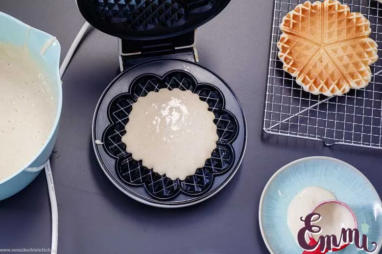 Waffelproduktion im Waffeleisen: Eine goldbraune Waffel entsteht