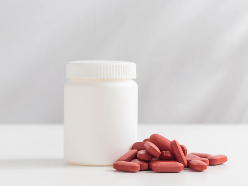 Weiße Dose mit roten Eisentabletten