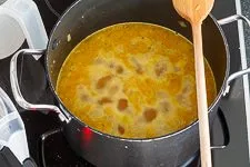 Ablöschen: Gemüsebrühe und Orangensaft werden zum Gemüse gegeben und aufgekocht