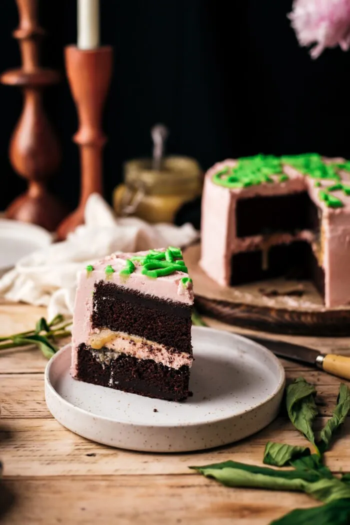 angeschnittener veganer Schokoladenkuchen auf einem Teller mit Harry Potter Geburtstagskuchen im Hintergrund