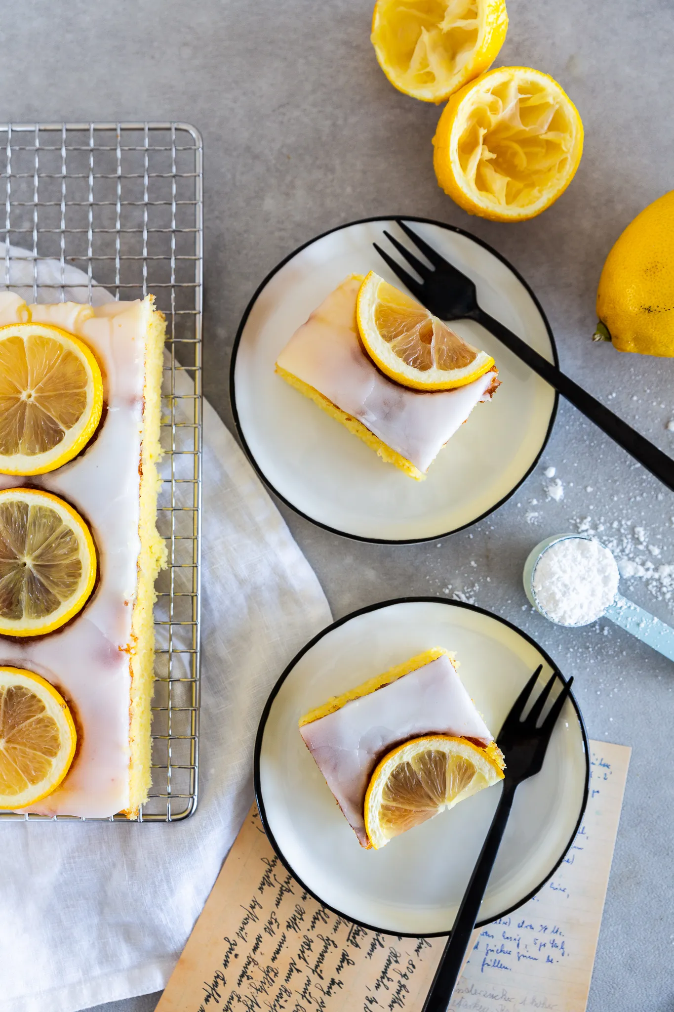 Angeschnittener Zitronenkuchen vom Blech, der seine fluffige und saftige Textur zeigt.