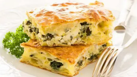 Angeschnittenes Börek mit Spinat-Schafskäse-Füllung auf einem Teller