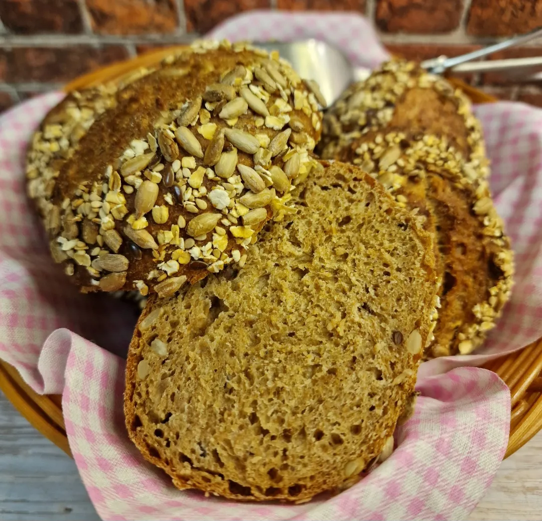 Angeschnittenes Vollkornbrot und Brötchen mit Butter