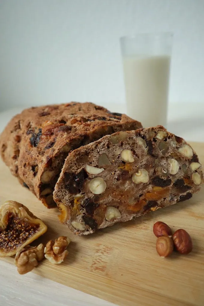 Ansicht eines frisch gebackenen Vollkorn-Früchtebrotes mit einem Glas Milch im Hintergrund