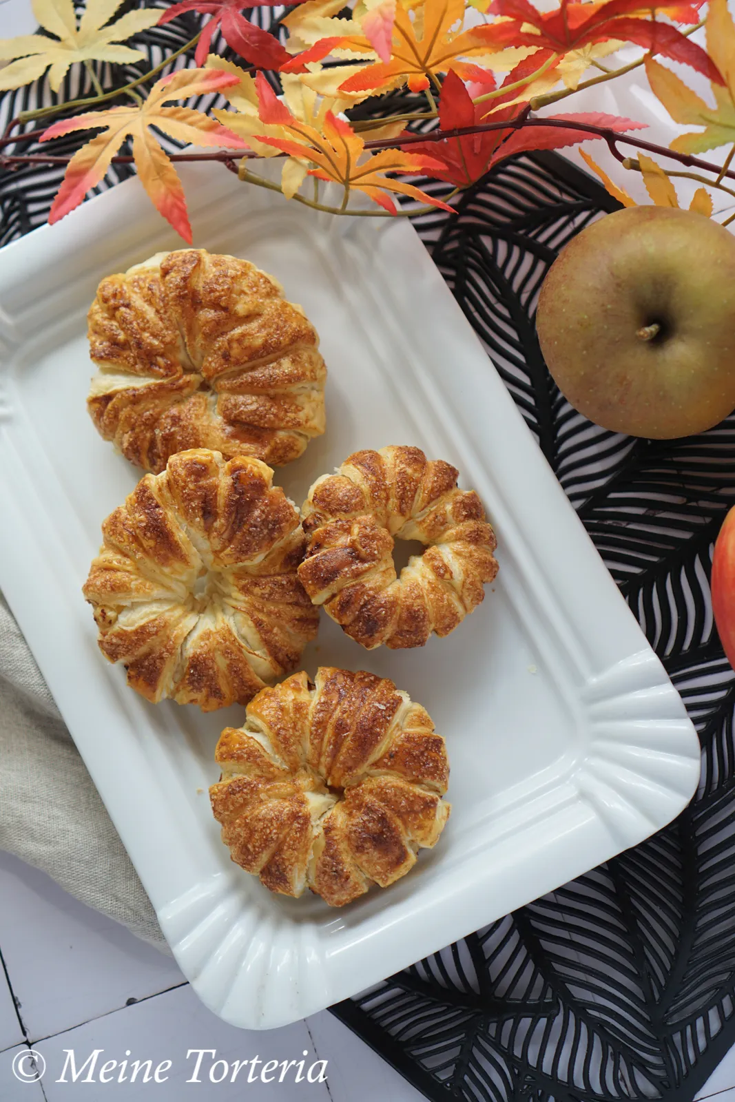 Appetitliche Apfel-Blätterteig-Ringe auf einem Teller, bereit zum Genuss