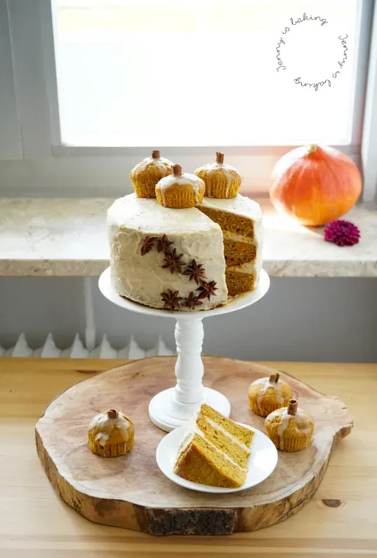 Aufgeschnittene Kürbistorte mit Cremeschichten und Deko-Kürbissen