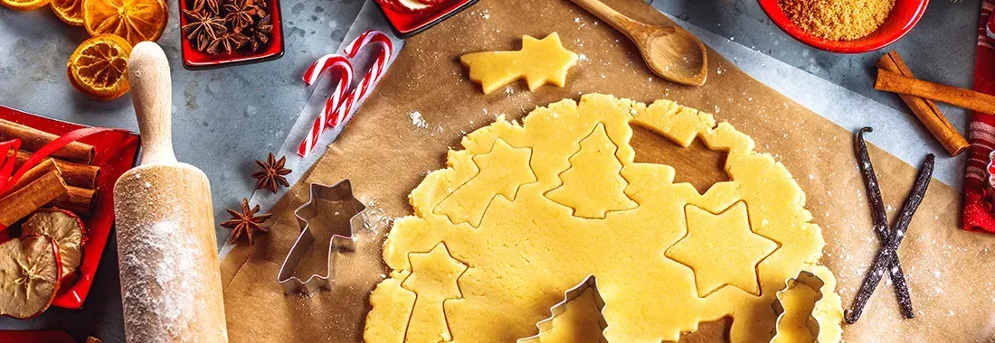 Auswahl an weihnachtlichen Backzutaten wie Nüsse, Trockenfrüchte und Gewürze