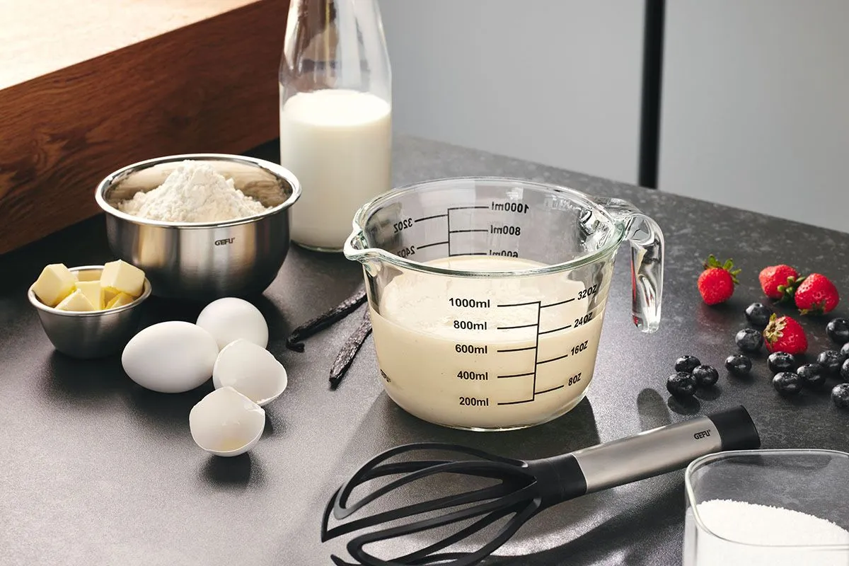 Backzutaten wie Mehl, Eier, Milch und Früchte mit GEFU Messbecher in moderner Küche