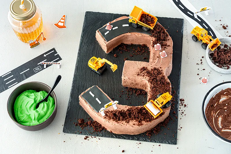 Baufahrzeuge und Schokokrümel auf der fertigen Bagger-Torte