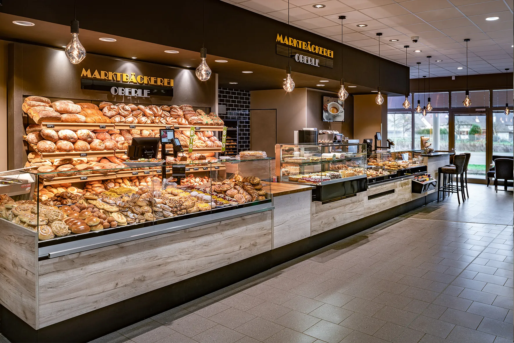 Blick auf das Café mit Sitzgelegenheiten bei EDEKA Oberle