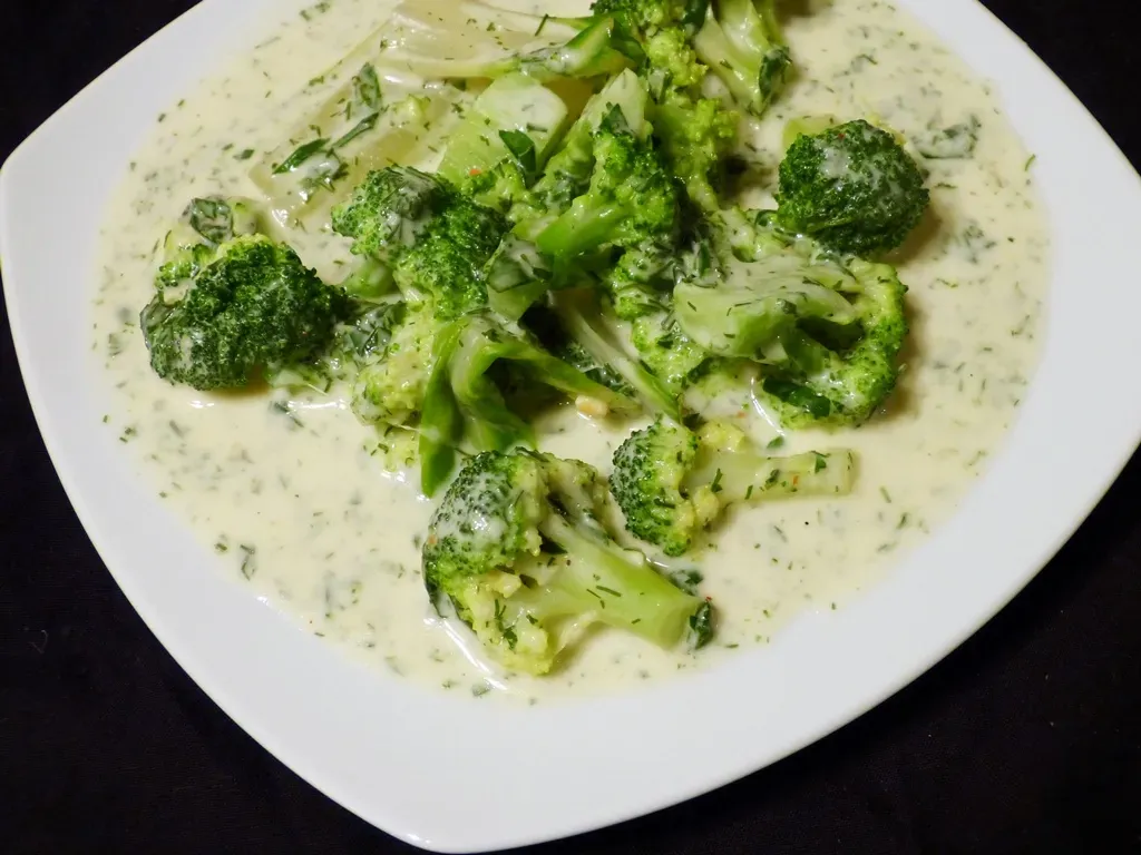 Brokkoli in cremiger Kräuter-Käsesauce, garniert mit frischen Kräutern