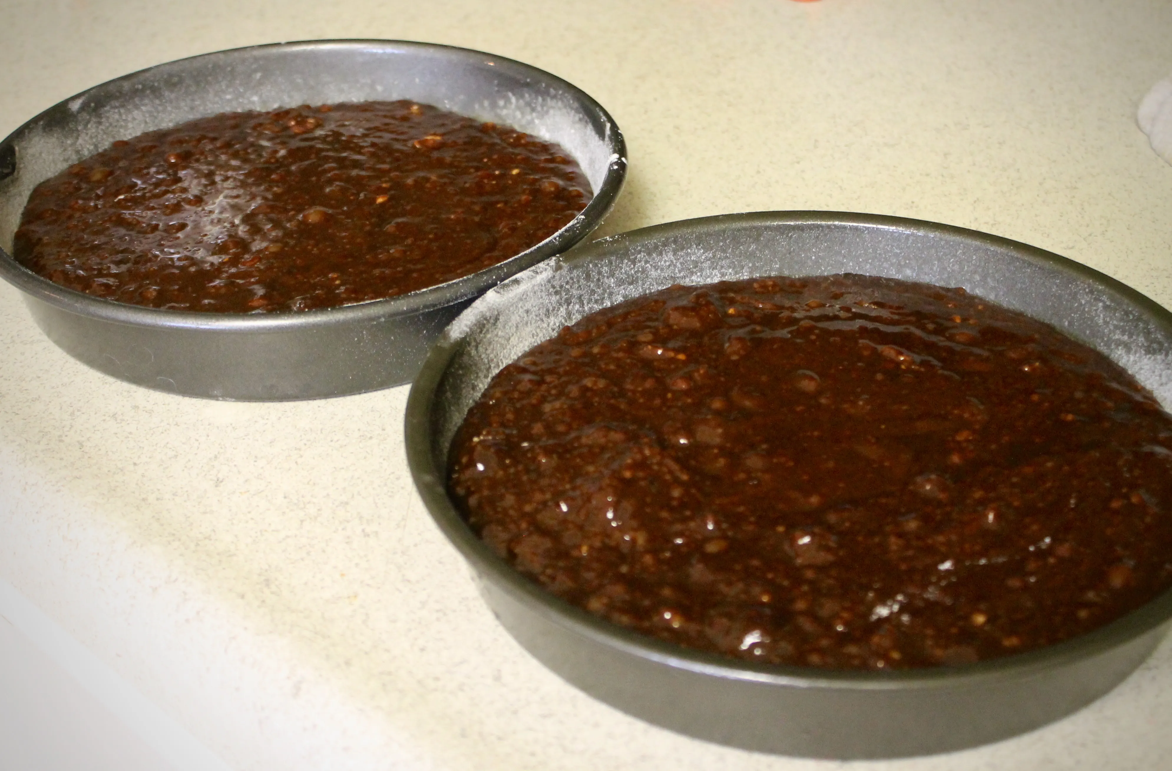 Brownie-Teig wird gleichmäßig in zwei Backformen gefüllt