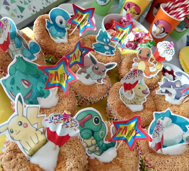 Bunte Muffins mit Pokémon Esspapier-Deko, dazu gesunde Snacks wie Tomaten, Gurken und Erdbeeren