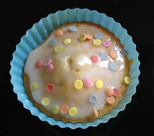 Buntes Zuckerkonfetti auf den feuchten Zuckerguss streuen