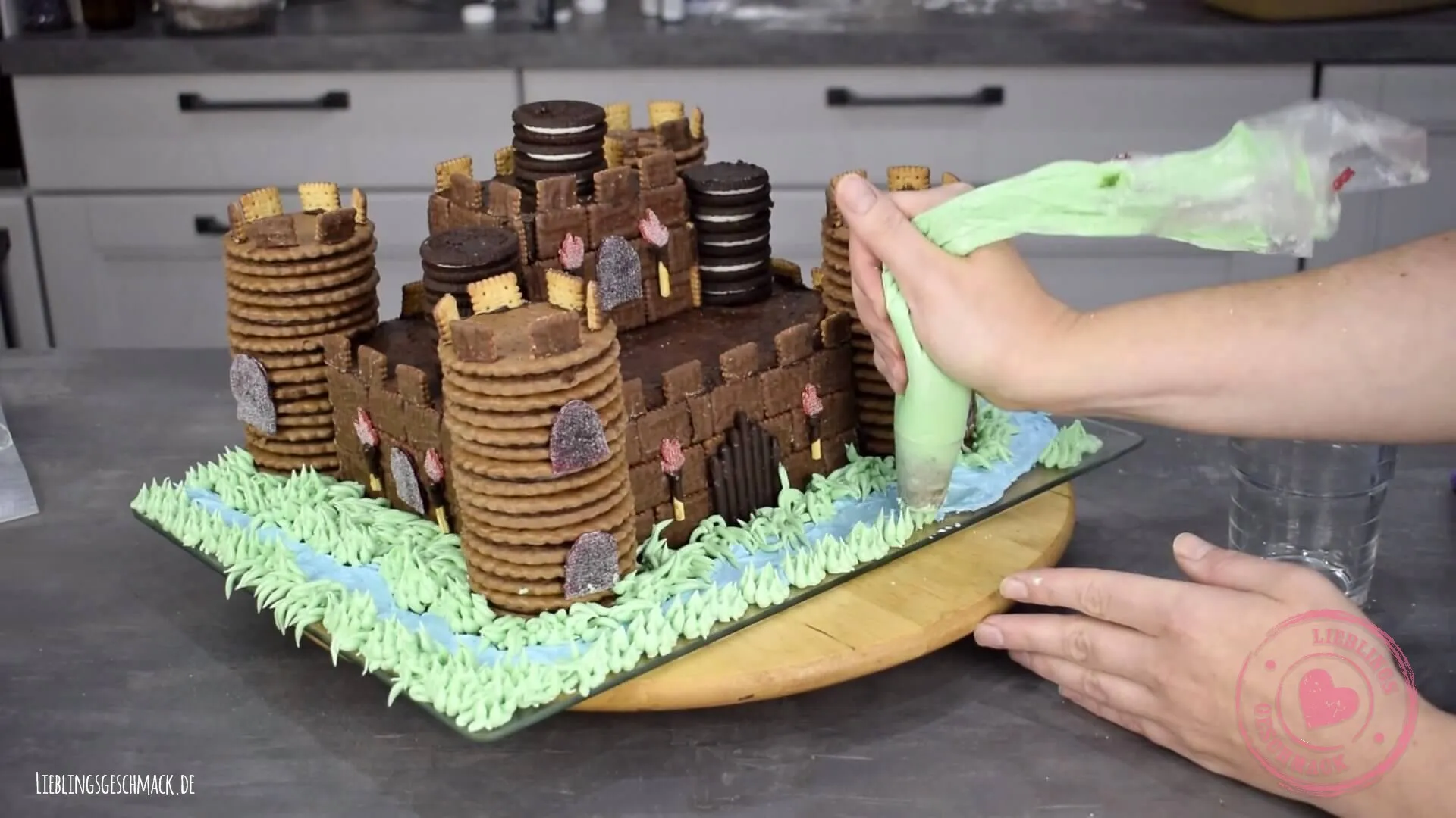 Burggraben mit Royal Icing und Falltor auf der Tortenplatte gestalten