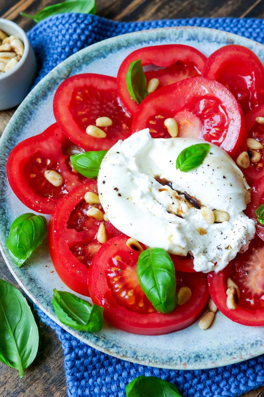 Burrata mit reifen Tomaten, frischem Basilikum und gerösteten Pinienkernen