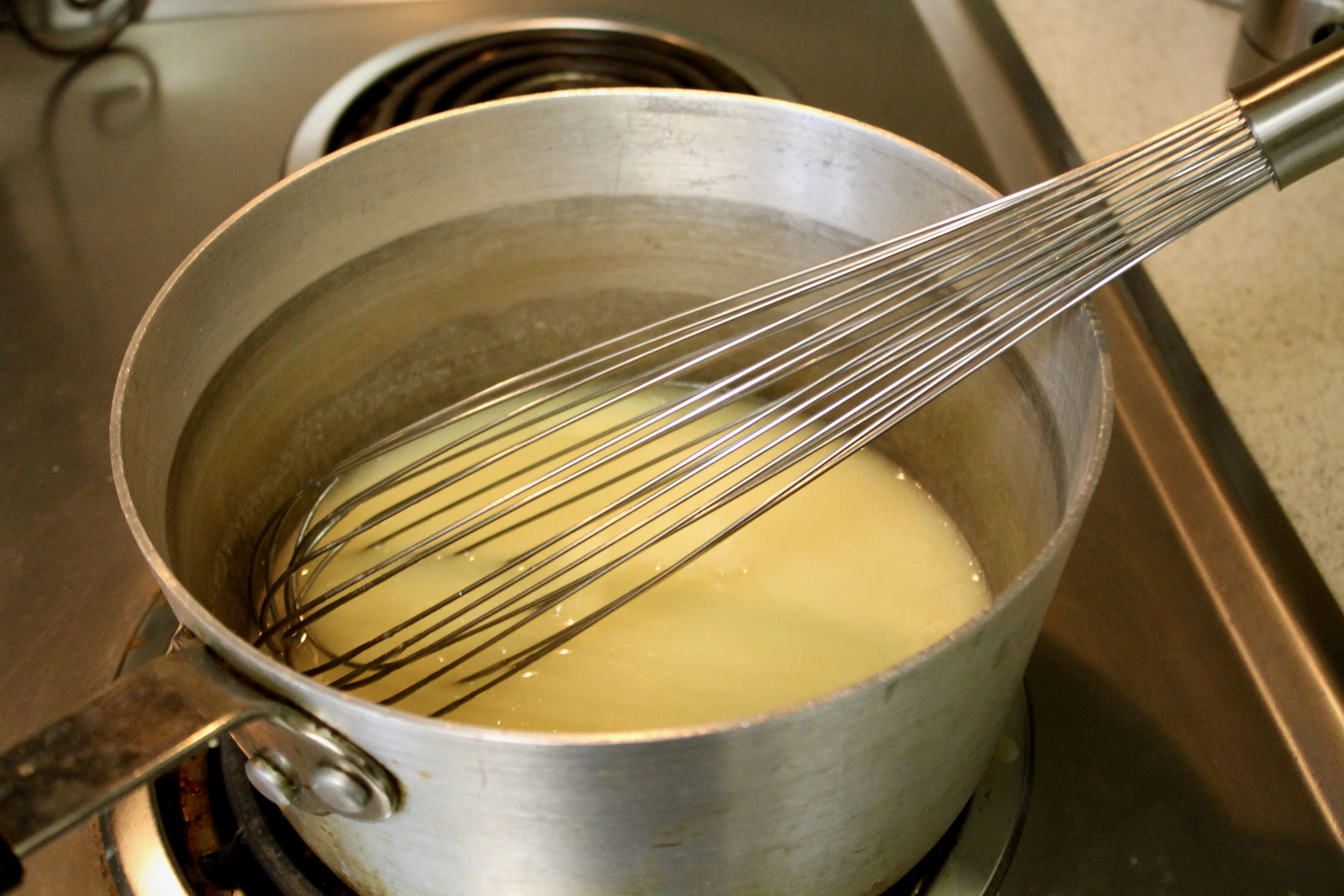 Butter und Maissirup in einer Schüssel, vermischt mit einem großen Schneebesen
