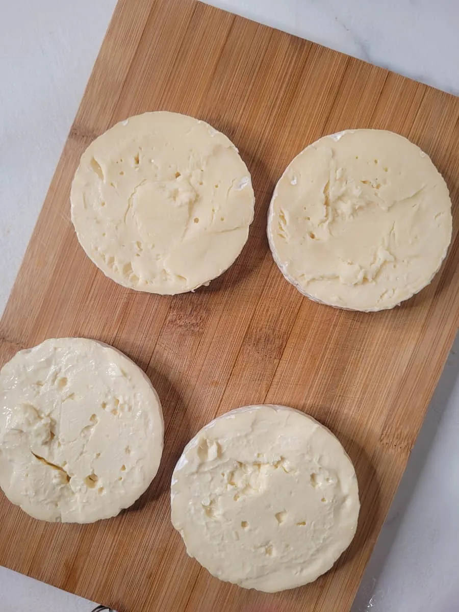 Camembert-Rad in der Mitte halbiert auf einem Holzbrett