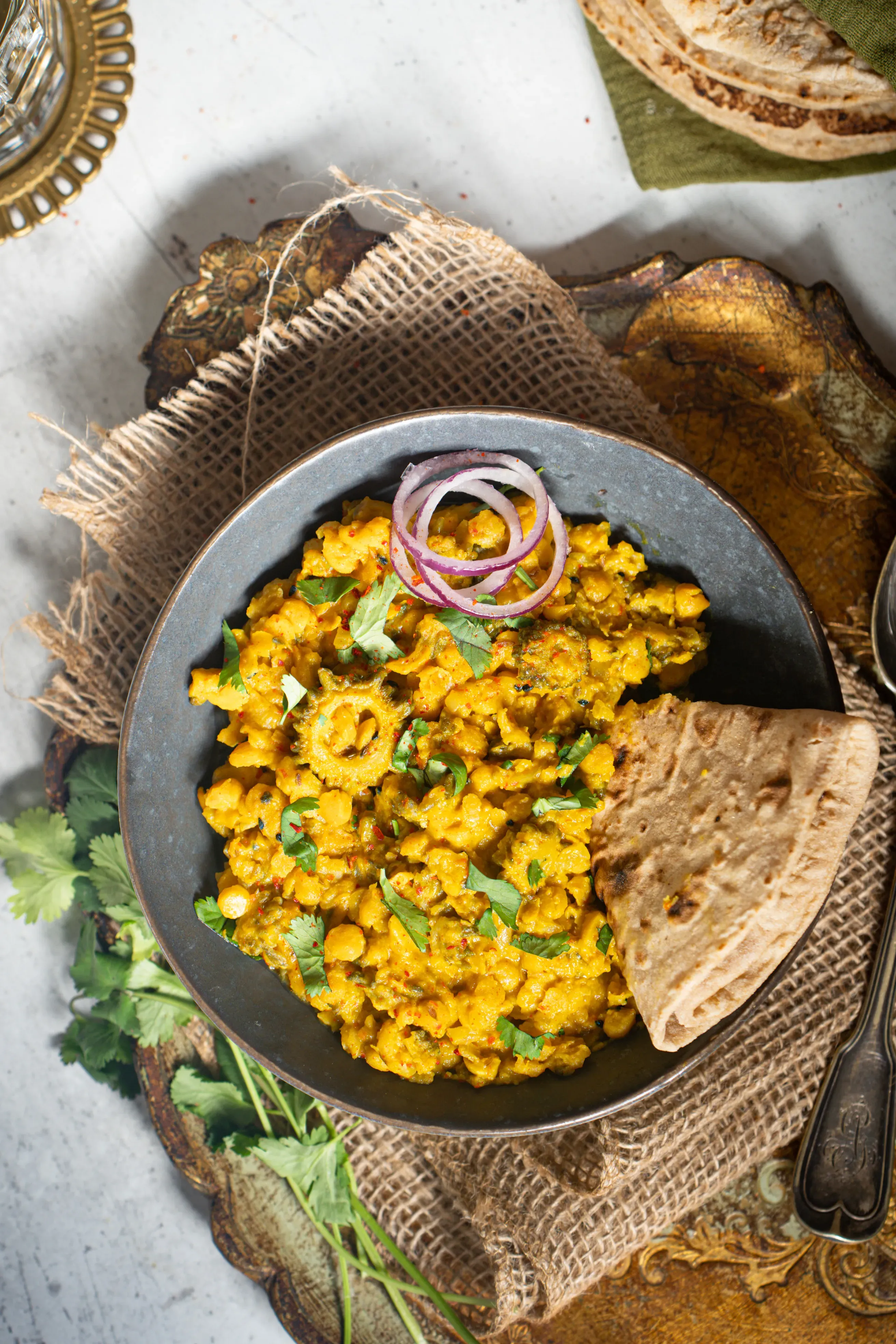 Chana Dal Karela in einer Schale serviert, garniert mit frischem Koriander