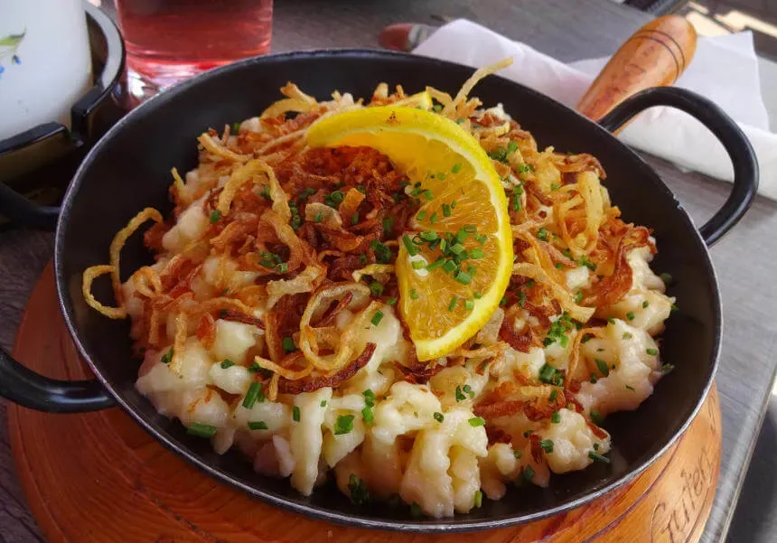 Cremige Käsespätzle, überbacken und mit Röstzwiebeln garniert.