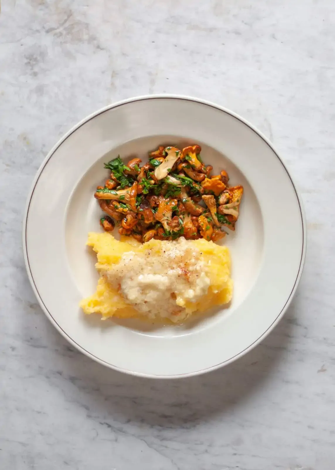 Cremige Polenta wird mit frischen Waldpilzen garniert serviert