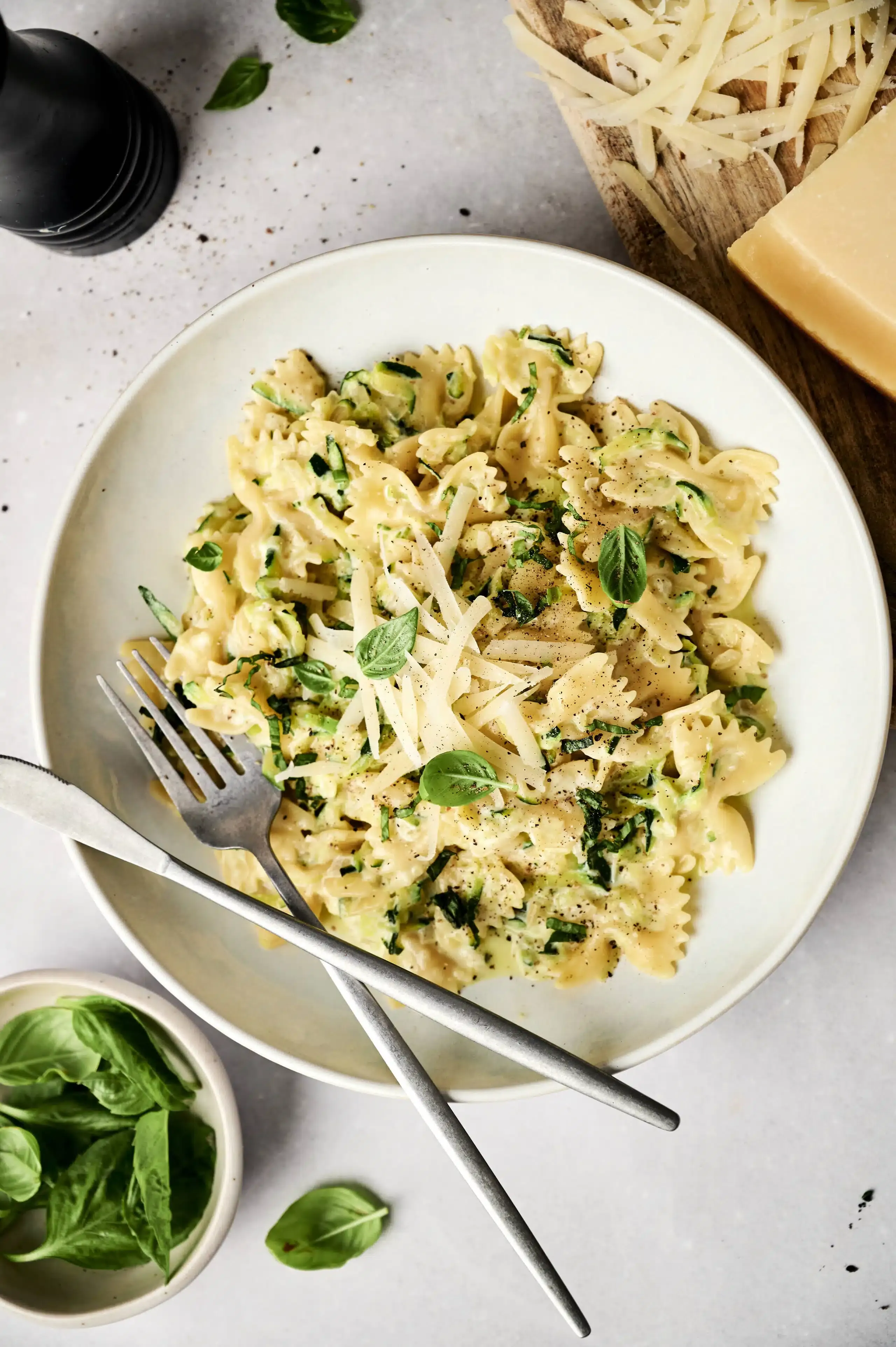 Cremige Zucchini Pasta auf einem weißen Teller mit Gabel
