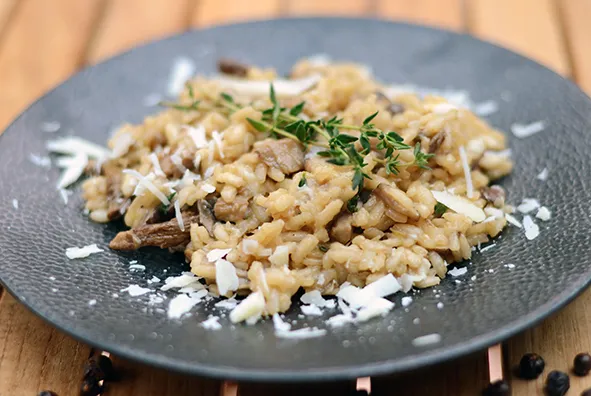 Cremiges Pilz-Risotto, garniert mit frischen Kräutern