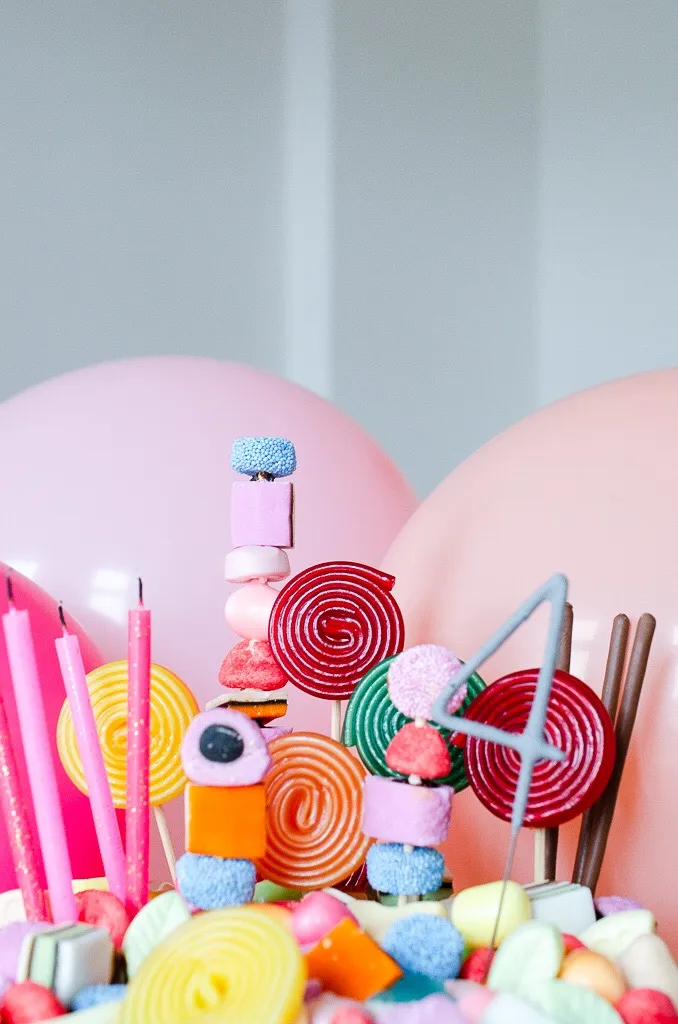 Der Candy Cake im Dekorationsprozess mit auf Spießen gesteckten Süßigkeiten