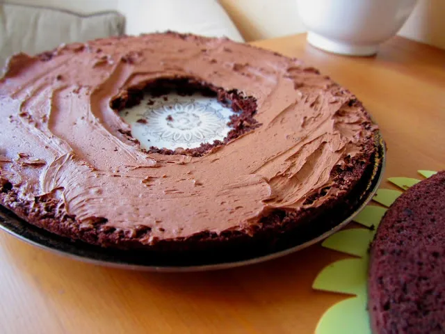 Der erste Kuchenboden wird mit cremiger Schokocreme bestrichen