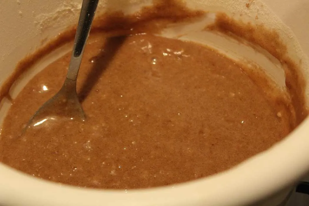 Der fertige Kuchenteig wird mit einem Löffel glattgerührt