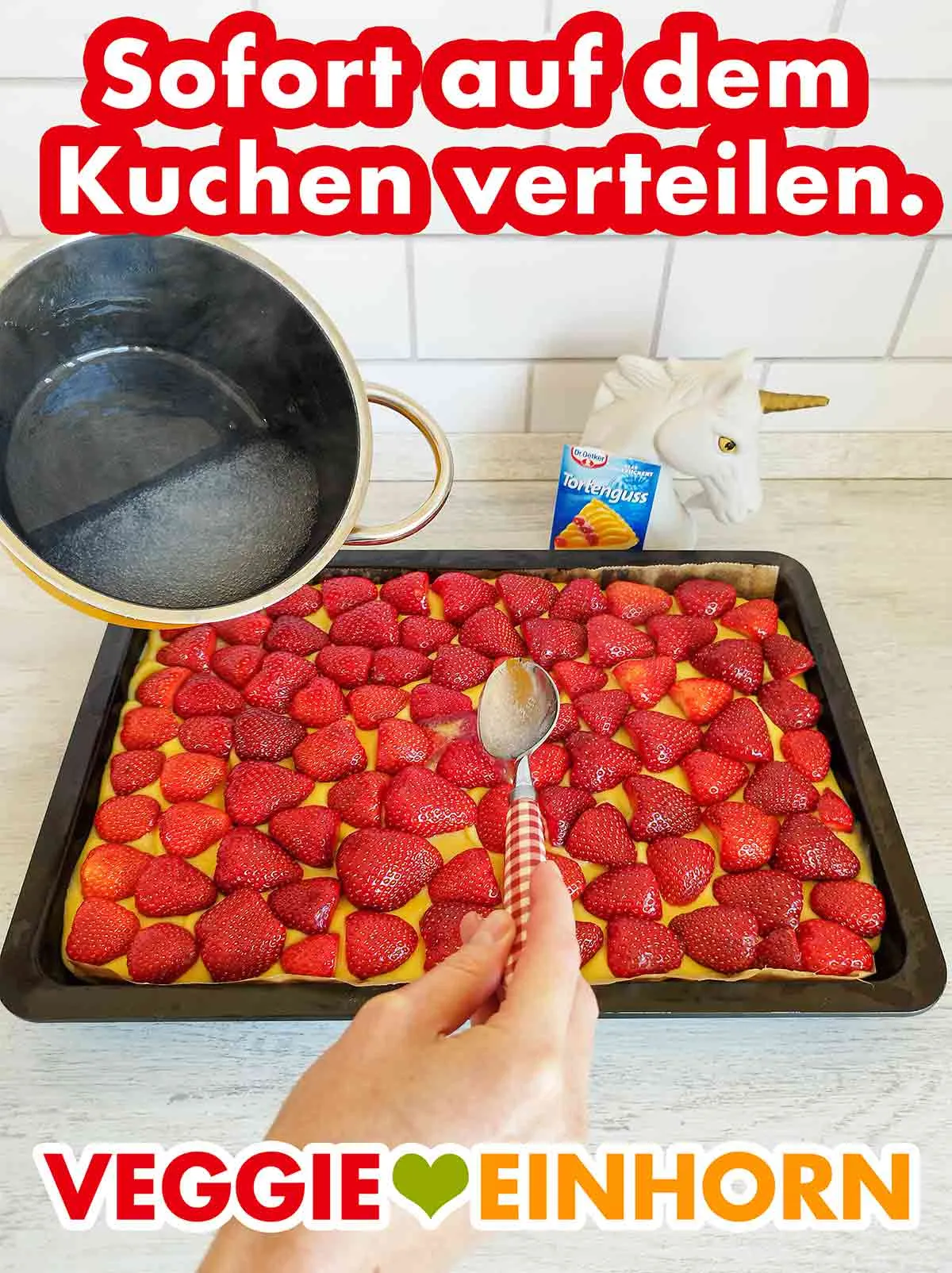 Der klare Tortenguss von Dr. Oetker wird auf einem veganen Erdbeerkuchen verteilt.