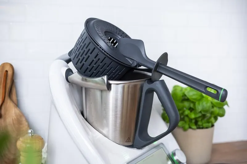 Der Spatel wird verwendet, um den gekochten Reis im Garkorb sicher über dem Mixtopf abtropfen zu lassen.