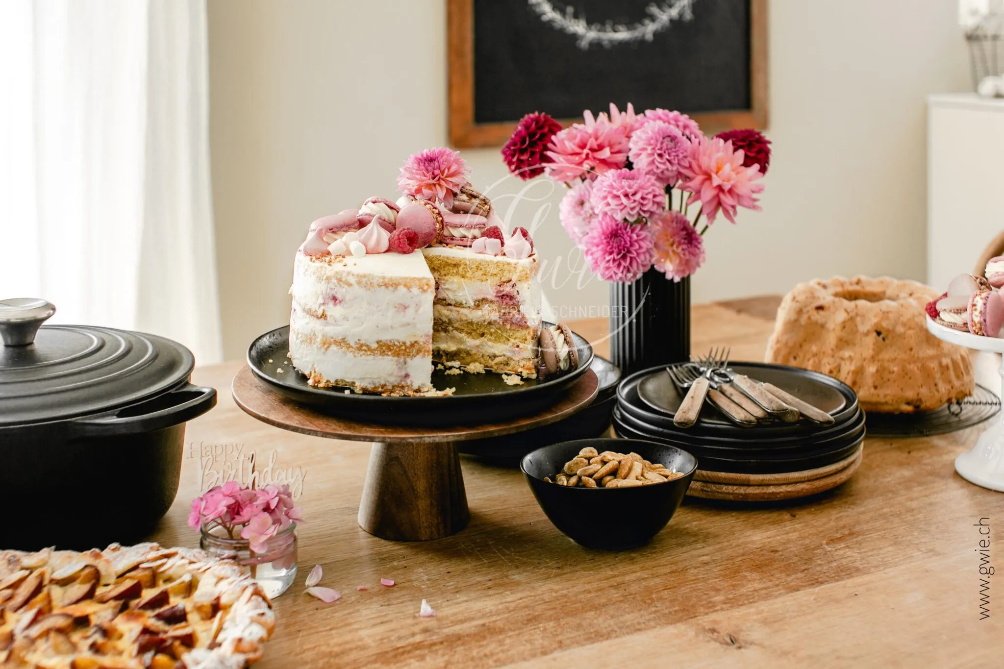 Detailaufnahme einer festlichen Torte mit Macarons und frischen Himbeeren