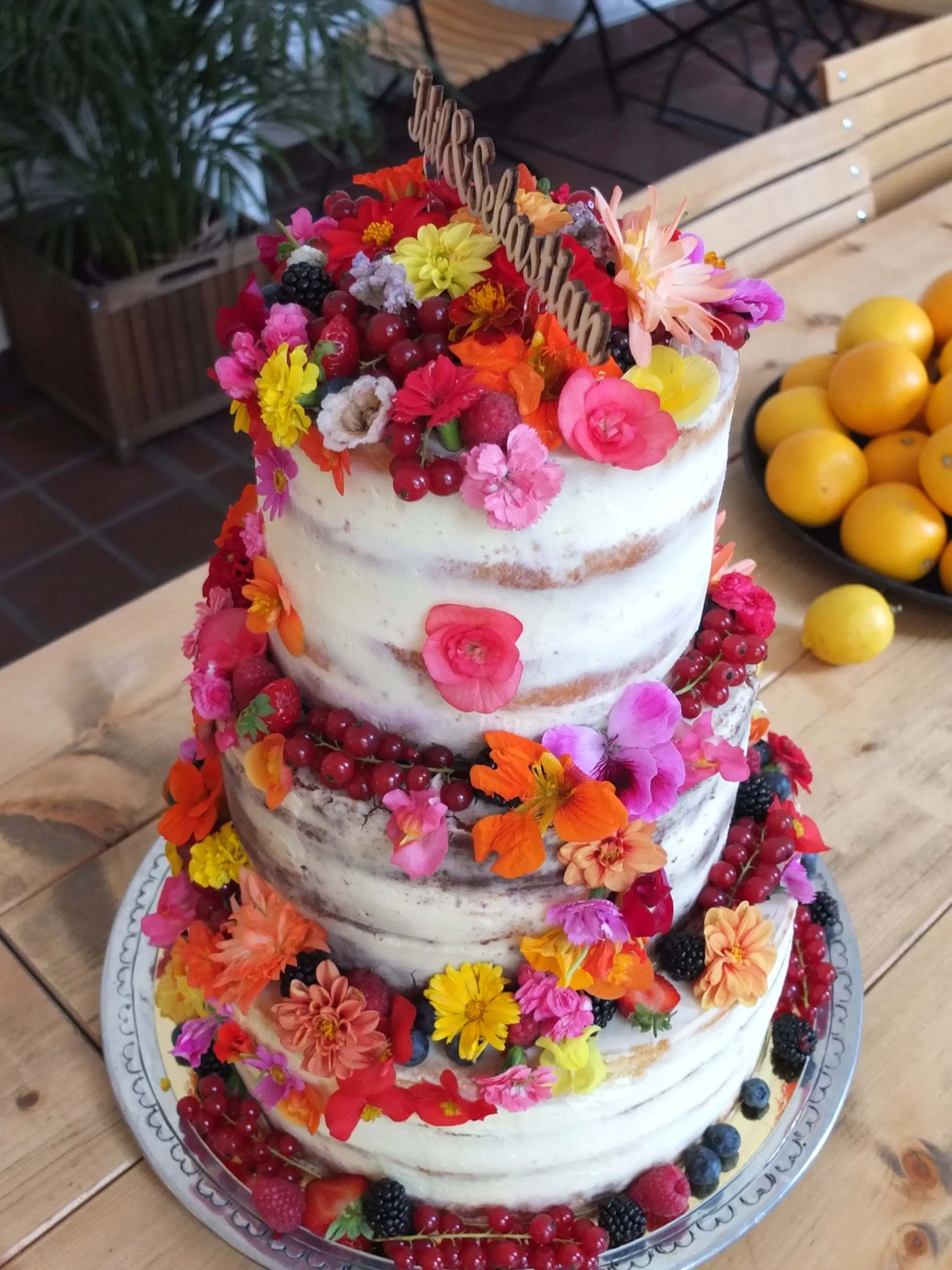 Detailaufnahme einer Hochzeitstorte mit Macarons und frischen Beeren